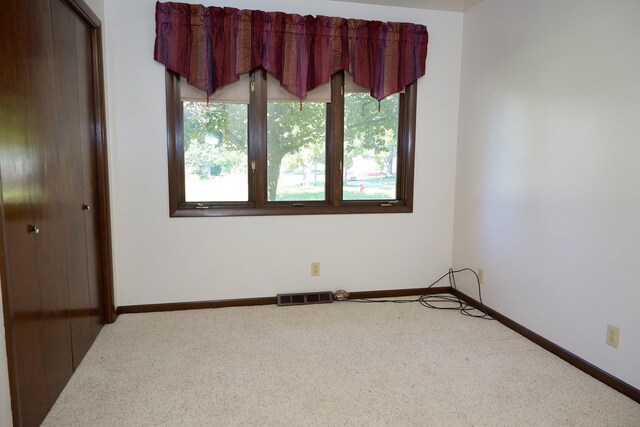 unfurnished room with carpet floors, baseboards, and visible vents