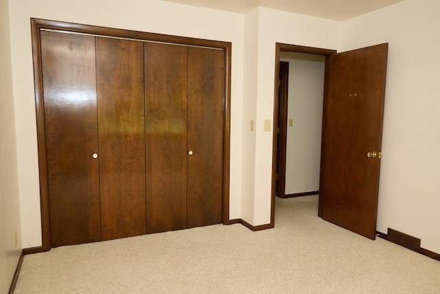 unfurnished bedroom with a closet, carpet flooring, and baseboards