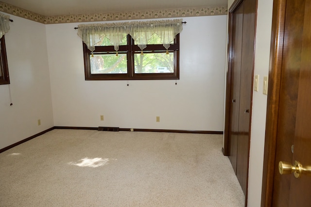 spare room featuring baseboards, visible vents, and carpet flooring