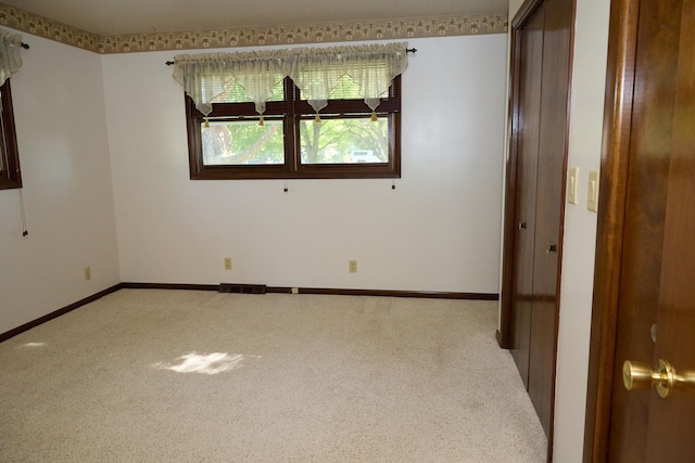 carpeted empty room with visible vents and baseboards
