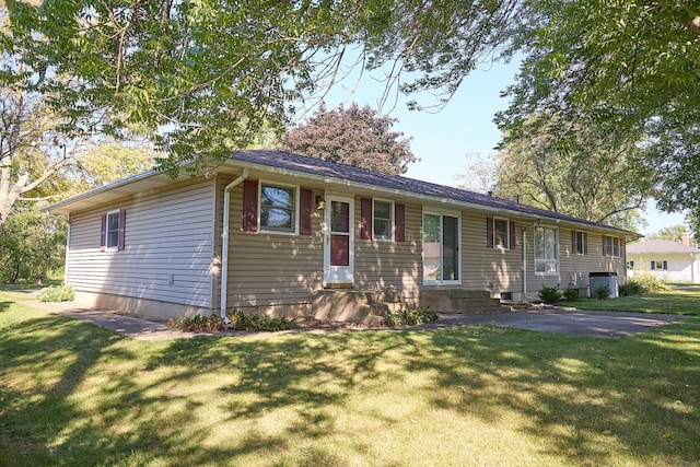 ranch-style home featuring a front lawn and central AC unit