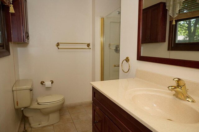 bathroom with tile patterned floors, toilet, a shower, baseboards, and vanity