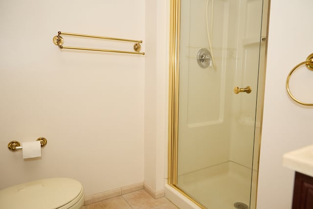 bathroom featuring baseboards, toilet, tile patterned flooring, vanity, and a shower stall