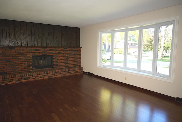 unfurnished living room with baseboards and dark wood-type flooring