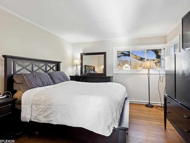 bedroom with hardwood / wood-style floors and crown molding