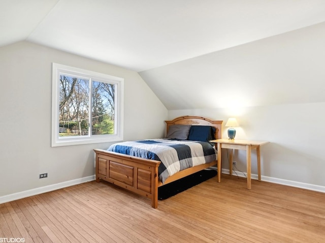 bedroom featuring light hardwood / wood-style floors and lofted ceiling