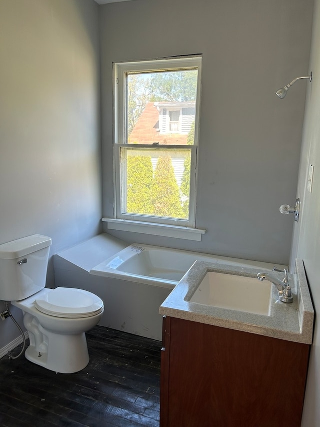 bathroom with a tub to relax in, toilet, wood-type flooring, and vanity