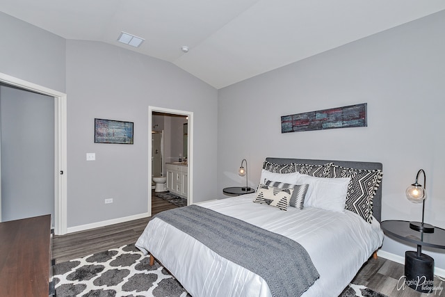 bedroom with vaulted ceiling, connected bathroom, and dark wood-type flooring