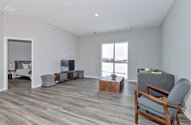 living area with hardwood / wood-style floors and vaulted ceiling