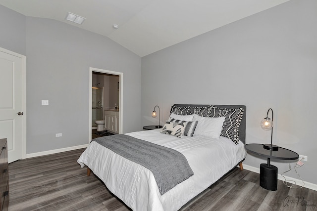 bedroom with lofted ceiling, ensuite bath, and dark hardwood / wood-style flooring