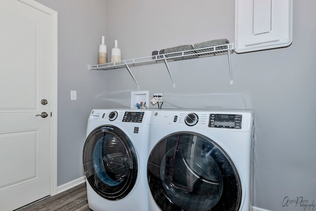 clothes washing area featuring dark wood-type flooring and washer and dryer