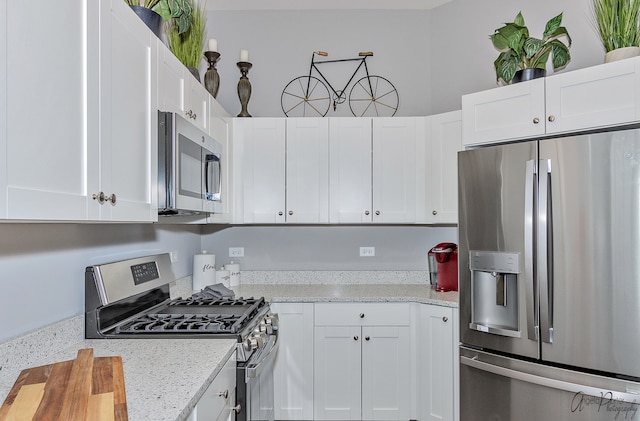 kitchen featuring light stone countertops, appliances with stainless steel finishes, and white cabinets