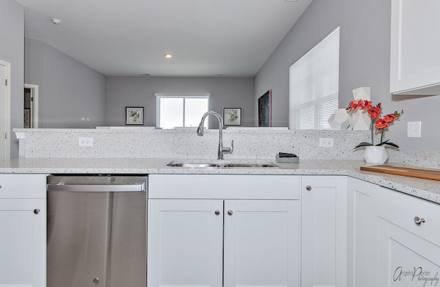 kitchen with dishwasher, white cabinetry, light stone counters, and sink