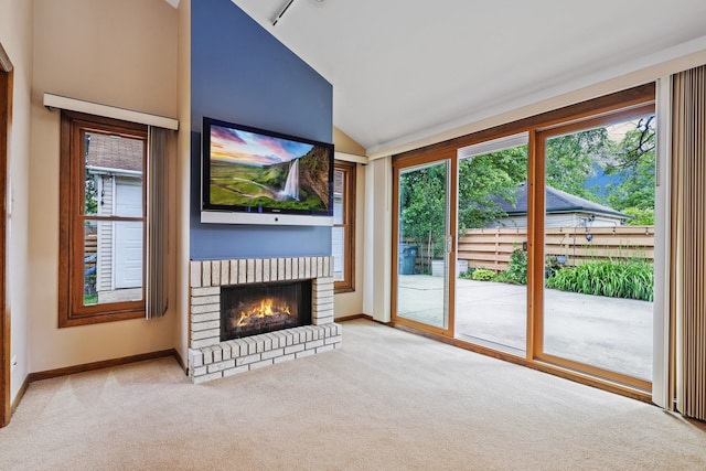 unfurnished living room with a fireplace, light carpet, lofted ceiling, and a healthy amount of sunlight