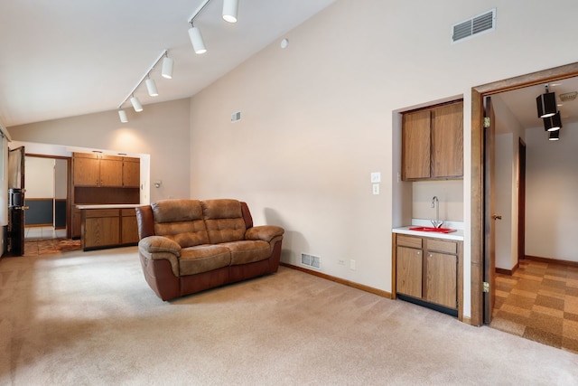 living room featuring light carpet, high vaulted ceiling, rail lighting, and sink