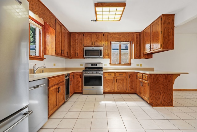 kitchen with sink, appliances with stainless steel finishes, and light tile patterned flooring