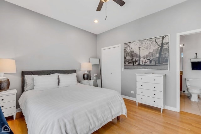 bedroom with light hardwood / wood-style floors, ceiling fan, and ensuite bathroom