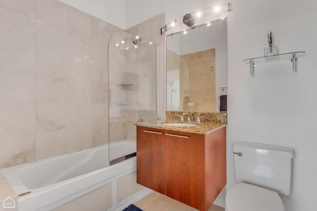 full bathroom featuring tiled shower / bath, vanity, tile patterned flooring, and toilet