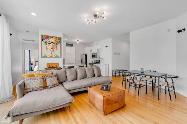 living room with light hardwood / wood-style floors and a chandelier