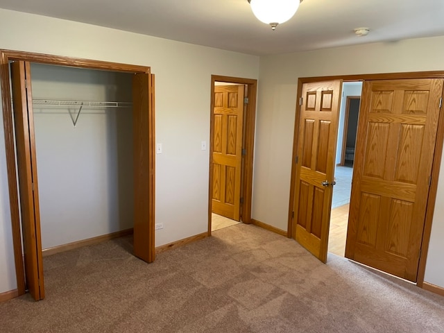 unfurnished bedroom featuring a closet and light carpet