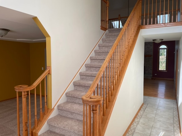 staircase with crown molding and wood-type flooring