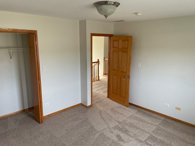 unfurnished bedroom featuring a closet and light carpet