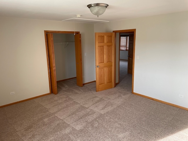 unfurnished bedroom featuring a closet and light colored carpet