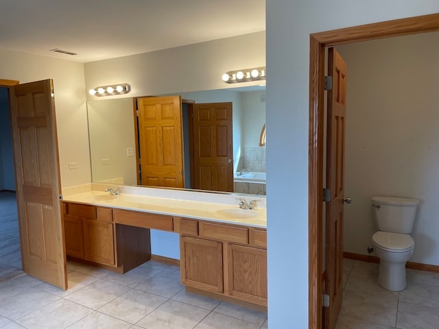 bathroom with vanity, toilet, tile patterned floors, and a washtub