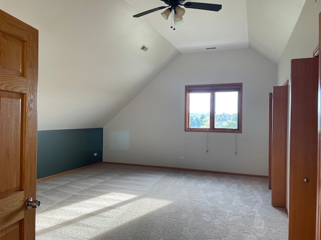 additional living space featuring vaulted ceiling, light colored carpet, and ceiling fan