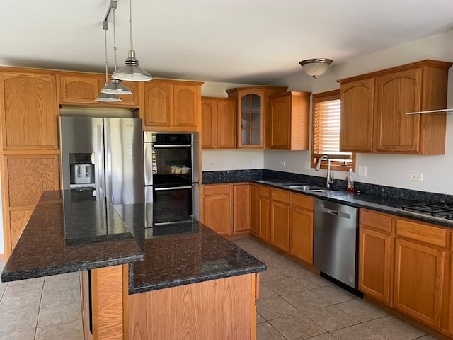 kitchen with a kitchen island, pendant lighting, light tile patterned floors, stainless steel appliances, and sink