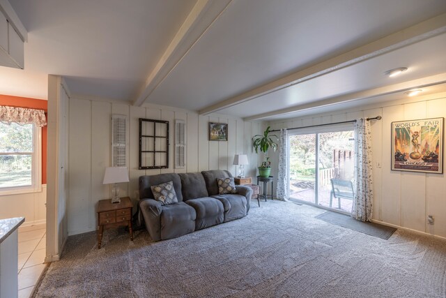 carpeted living room featuring plenty of natural light and beamed ceiling