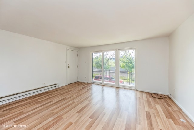 unfurnished room featuring light wood-type flooring and baseboard heating