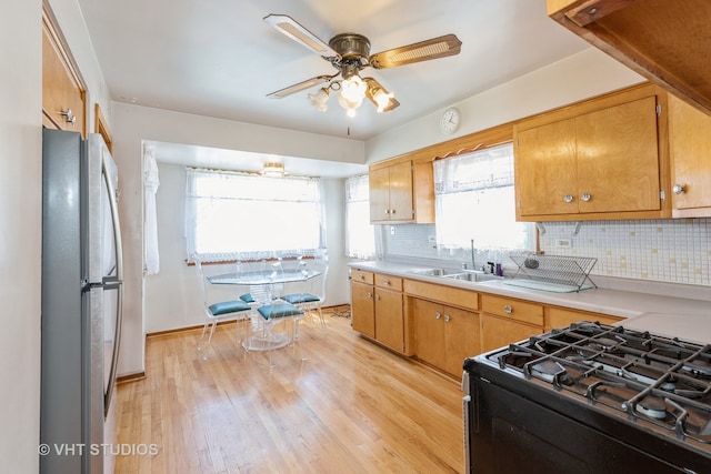 kitchen with a wealth of natural light, sink, stainless steel fridge, and black range with gas stovetop