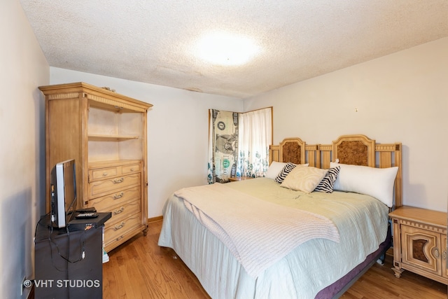 bedroom with a textured ceiling and hardwood / wood-style floors