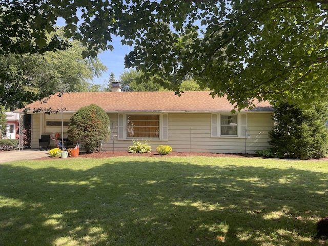 ranch-style home featuring driveway, a front lawn, a chimney, and an attached garage