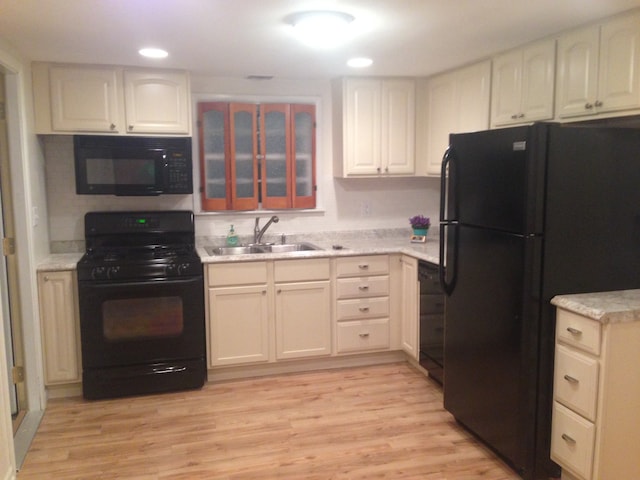 kitchen featuring black appliances, sink, white cabinets, and light hardwood / wood-style floors