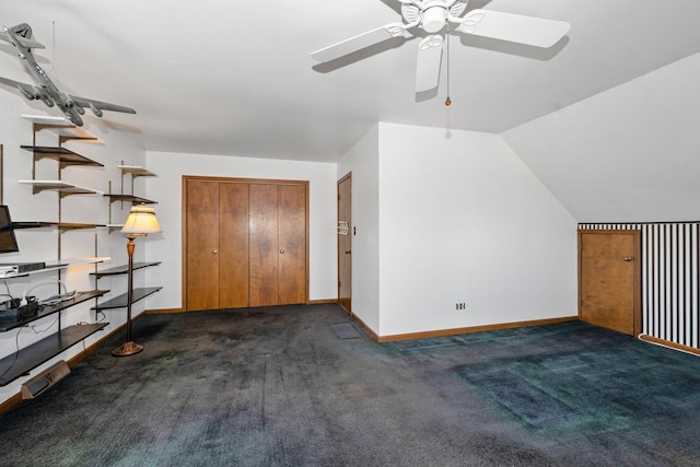 additional living space featuring dark colored carpet, vaulted ceiling, and ceiling fan