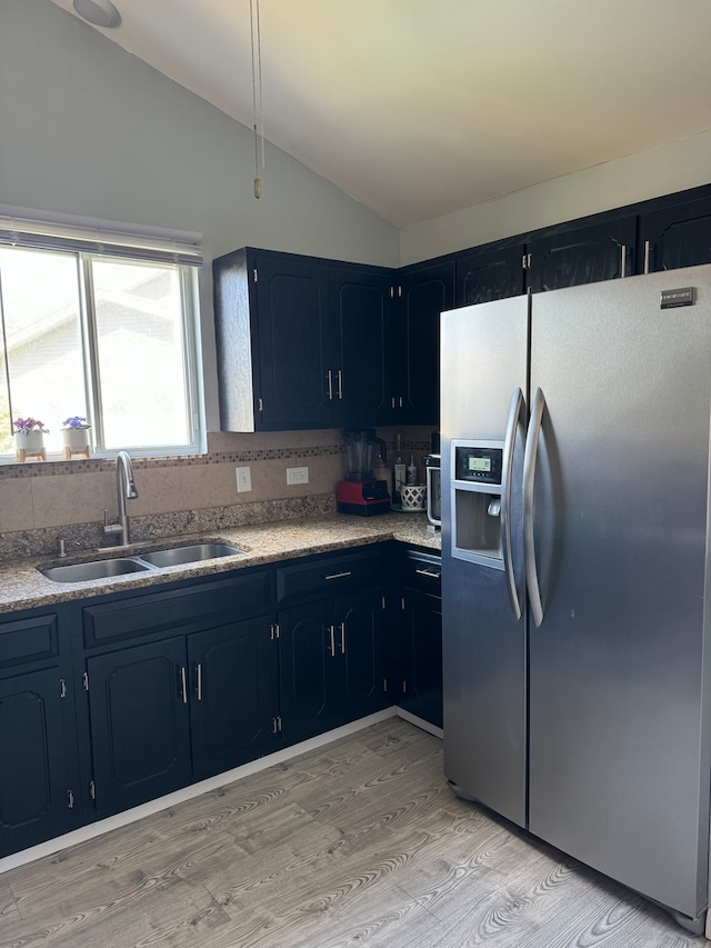 kitchen with stainless steel fridge with ice dispenser, light wood-type flooring, lofted ceiling, and sink