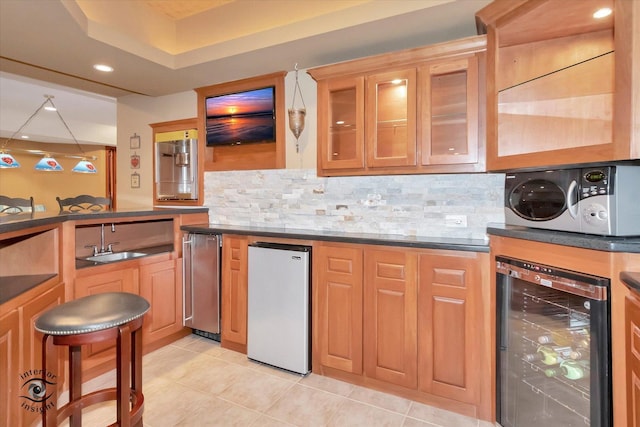 kitchen with sink, light tile patterned floors, fridge, decorative backsplash, and beverage cooler