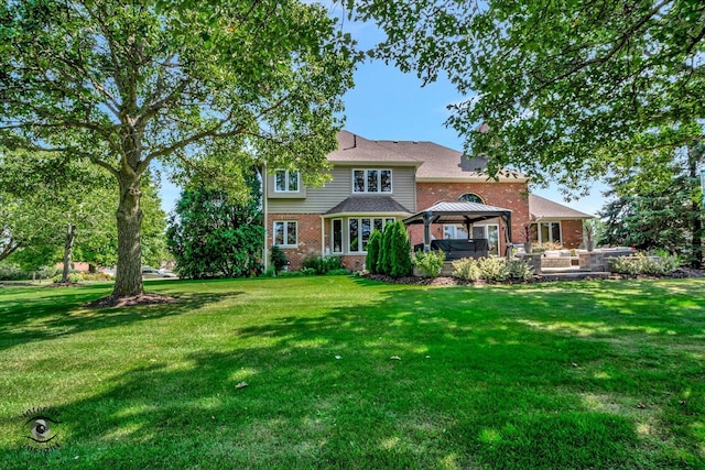 rear view of house with a gazebo and a yard