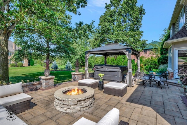 view of patio / terrace featuring a hot tub, a gazebo, and an outdoor living space with a fire pit