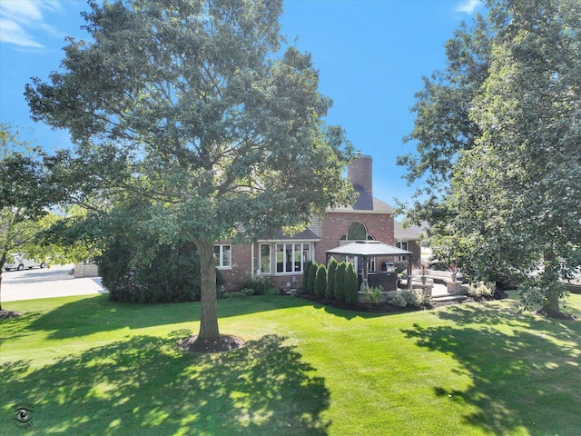 view of front of home featuring a gazebo and a front lawn