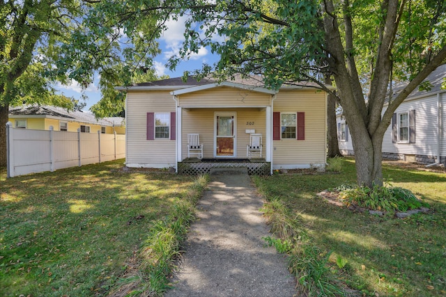 bungalow-style home with a front lawn and covered porch