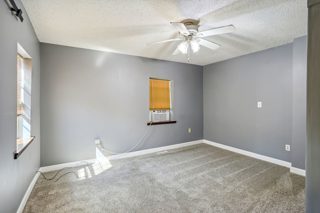 empty room featuring ceiling fan, a textured ceiling, and carpet