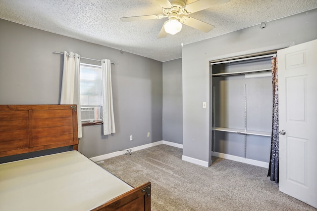 carpeted bedroom with a closet, ceiling fan, and a textured ceiling