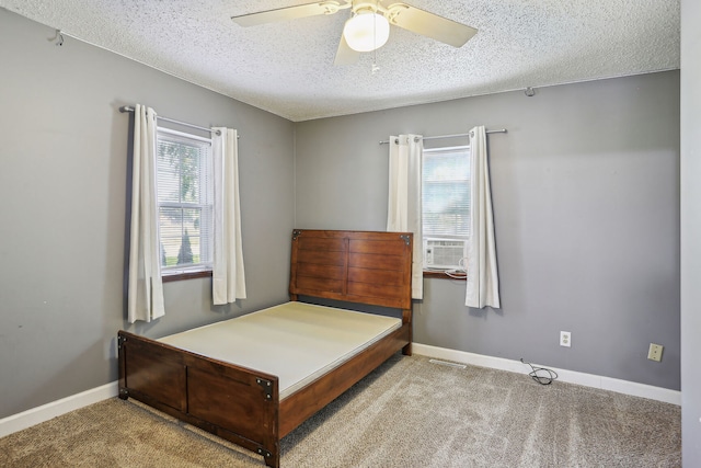 carpeted bedroom with ceiling fan and a textured ceiling