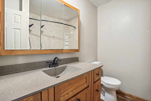 bathroom with vanity, toilet, a textured ceiling, walk in shower, and hardwood / wood-style floors