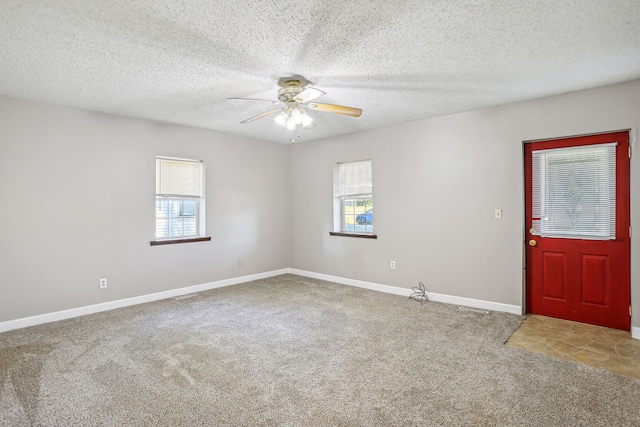 carpeted foyer entrance featuring ceiling fan and a textured ceiling