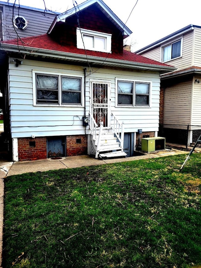 rear view of property featuring a lawn, crawl space, and entry steps