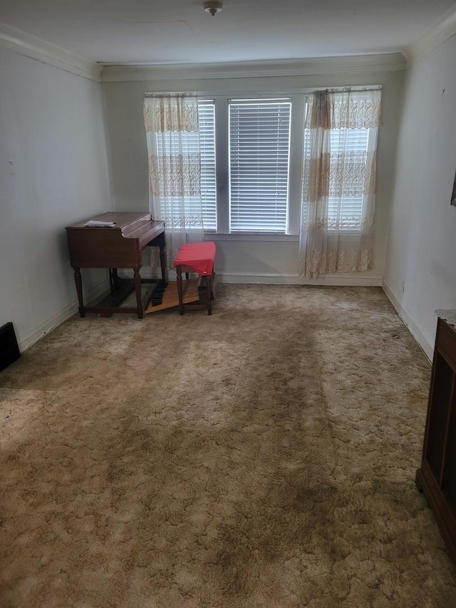 sitting room featuring baseboards, ornamental molding, carpet, and a healthy amount of sunlight